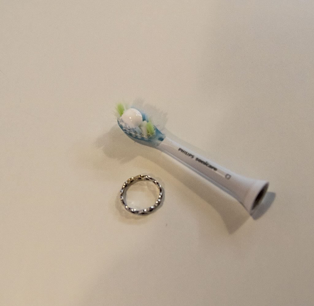 Zahnbürste mit Zahnpasta und Silberring
