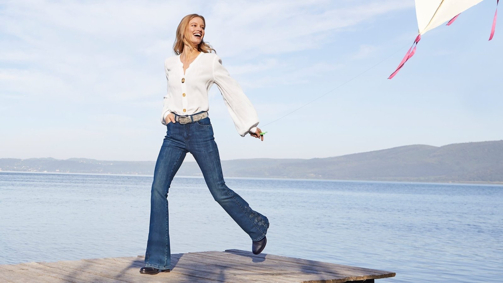 Frau mit weißer Bluse und Jeans.