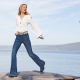 Frau mit weißer Bluse und Jeans.